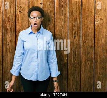 Belle jeune femme d'affaires américaine africaine sur fond isolé peur et choqué par l'expression de surprise, la peur et excité face. Banque D'Images