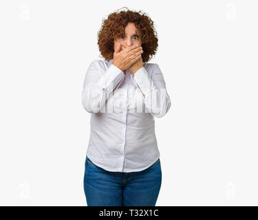 Beau milieu des affaires senior femme ager sur fond isolé choqué couvrant la bouche avec les mains pour l'erreur. Concept Secret. Banque D'Images