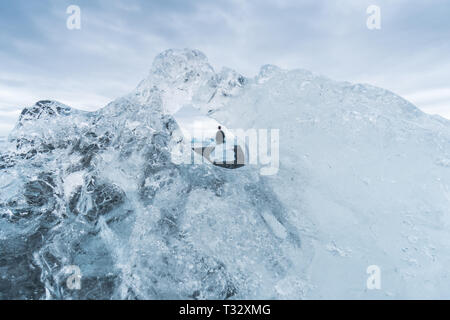 À travers le trou dans un iceberg donne une vue unique d'une personne alon sur plage du Diamant en Islande. Banque D'Images