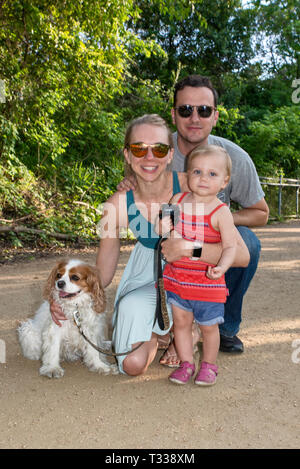 Père, mère, fille et bébé Cavalier King Charles Spaniel, sentier de Butler dans le parc Zilker à Austin, Texas, États-Unis Banque D'Images