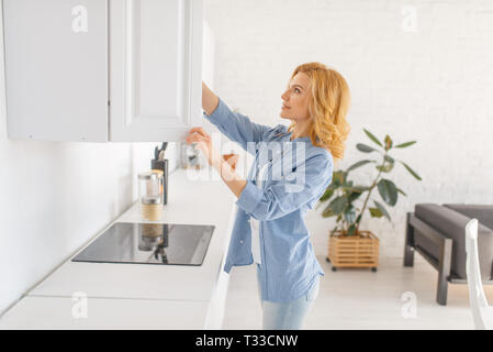 Happy woman se prépare à faire cuire un petit-déjeuner frais sur la cuisine. Personne de sexe féminin à la maison le matin, la nutrition saine Banque D'Images