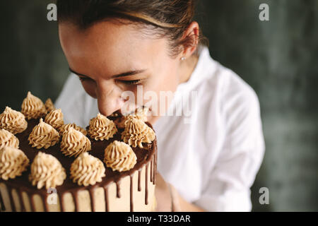 Confiseur femelle de prendre une bouchée d'un gâteau. Manger gâteau pâtissier. Banque D'Images