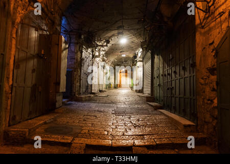 Rue pavées étroites dans la vieille ville médiévale avec des maisons illuminées et de chaussée. Photo de nuit de passage latéral dans certains vieux château. Portes fermées, ston Banque D'Images