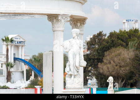 Sculpture de jeune femme tenant panier plein de fruits ou raisins près de colonnes corinthiennes dans un parc public. Réplique de la statue de la Grèce antique Banque D'Images