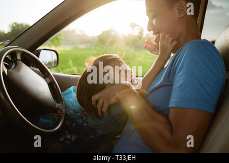 Papa de chatouiller sa petite fille dans la voiture Banque D'Images