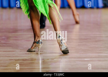 Jambes danseuse dans des chaussures et robe verte sur plancher de danse Banque D'Images