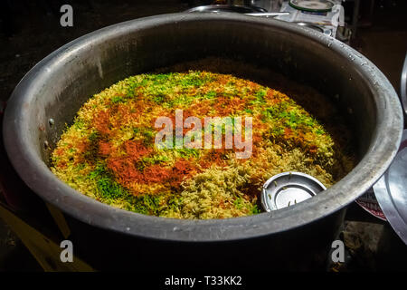 Riz frit nasi goreng au poulet et légumes sur une casserole. Riz frit traditionnel indien briyani. vert jaune et rouge de riz. Riz multicolore dans un Banque D'Images