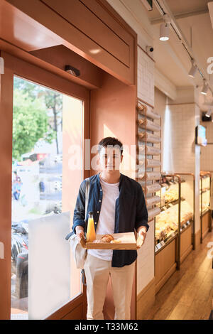 Bel asiatique homme acheter boulangerie pour pause café dans l'après-midi. Boulangerie et pause café. Banque D'Images