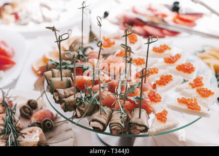 Des sandwichs avec du caviar rouge et apéritif au saumon sur une plaque blanche Banque D'Images