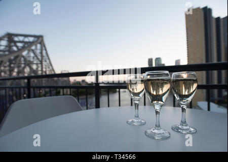 3 verres de vin sur un balcon de Brisbane avec la ville en arrière-plan. Banque D'Images