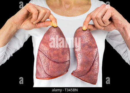 Personne humaine tient deux modèles pulmonaire en face de la poitrine blanc isolé sur fond noir Banque D'Images