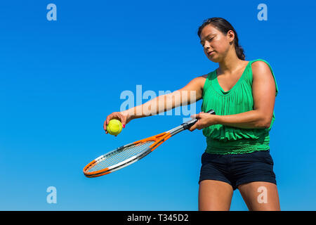 Young woman holding tennis racket colombien et la balle contre le ciel bleu Banque D'Images