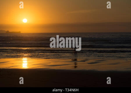 Deux surfeurs sur la plage au coucher du soleil, plage de Sopelana, Biscaye, Espagne Banque D'Images