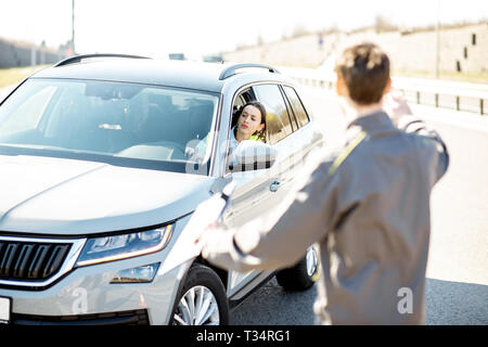 L'assistance routière d'aider les jeunes travailleurs Femme à sortir de la route après l'accident sur l'autoroute Banque D'Images