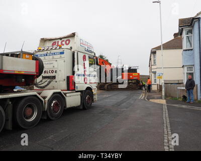 Sheerness, Kent, UK. 06 avril 2019. La récupération d'une excavatrice gridlocked endommagé par l'eau des routes sur les Île de Sheppey dans le Kent cet après-midi qu'il a fallu plusieurs heures pour récupérer sur Marine Parade, Sheerness par le club de voile. Un camion de récupération et une autre grande pelle hydraulique ont été utilisées pour essayer de manœuvrer le pelle cassée sur une remorque. Travailler à charger sur la remorque a débuté à 13h30, mais s'est jusqu'à 17h. La première excavatrice ont échoué à travailler sur les défenses de la mer pour l'Agence de l'environnement, et a été submergé par la mer après le tuyau du moteur a éclaté le 14 mars. Credit : James Bell/Alamy Live News Banque D'Images