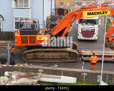 Sheerness, Kent, UK. 06 avril 2019. La récupération d'une excavatrice gridlocked endommagé par l'eau des routes sur les Île de Sheppey dans le Kent cet après-midi qu'il a fallu plusieurs heures pour récupérer sur Marine Parade, Sheerness par le club de voile. Un camion de récupération et une autre grande pelle hydraulique ont été utilisées pour essayer de manœuvrer le pelle cassée sur une remorque. Travailler à charger sur la remorque a débuté à 13h30, mais s'est jusqu'à 17h. La première excavatrice ont échoué à travailler sur les défenses de la mer pour l'Agence de l'environnement, et a été submergé par la mer après le tuyau du moteur a éclaté le 14 mars. Credit : James Bell/Alamy Live News Banque D'Images