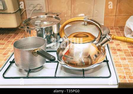 Casseroles, une poêle et une bouilloire sur la cuisinière à gaz Banque D'Images