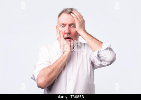 Les gars en chemise blanche à la satisfait et fatigué. Il a une mauvaise journée, pense à ses problèmes au travail. Banque D'Images
