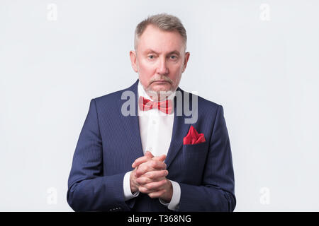 Senior businessman en costume bleu et cravate rouge à la confiance à l'appareil photo. Isolé sur fond blanc, shoot studio Banque D'Images