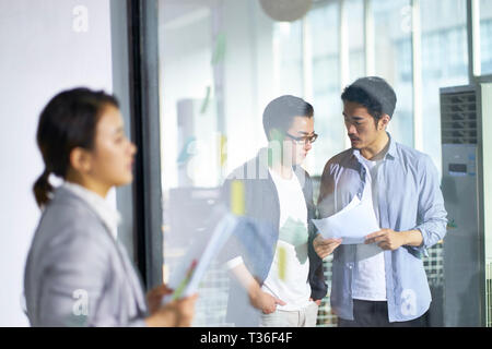 Young Asian business woman et les hommes qui travaillent dans le bureau. Banque D'Images