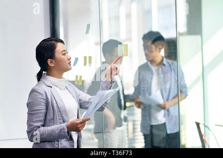 Young Asian business woman et les hommes qui travaillent dans le bureau. Banque D'Images