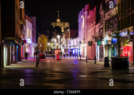 Vue jusqu'Peascod vers le château de Windsor dans la nuit. Les lumières des magasins illuminent la rue d'une lueur multicolore. Banque D'Images