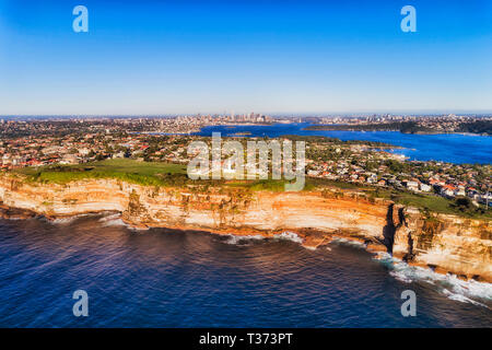 Bord de falaise de grès banlieue Est de Sydney face à l'océan Pacifique en vue aérienne sur la ville et le port distant CBD sur l'horizon. Banque D'Images