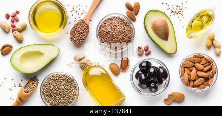 L'avocat, les amandes, les graines de chanvre, linseeds, olives et huiles sur fond blanc, vue du dessus. Autre concept huiles Banque D'Images