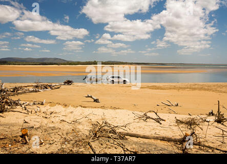 Le remorquage du véhicule quatre roues motrices canot / bateau sur l'estuaire de la plage à côté de vastes zones côtières sous ciel bleu à Eurimbulah National Park Queensland Australie Banque D'Images