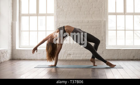 Young woman practicing yoga in Wild chose Camatkarasana, pose Banque D'Images