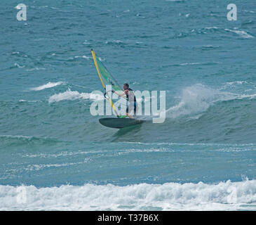 Wind surfer équitation vagues sur bleu de l'océan Pacifique au large de la côte du parc national en eau profonde dans le Queensland en Australie Banque D'Images