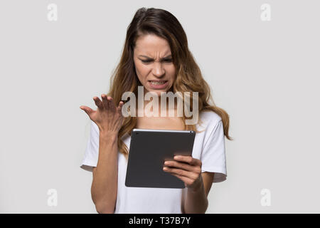 Femme irritée à la tablette à l'écran se sent en colère Banque D'Images