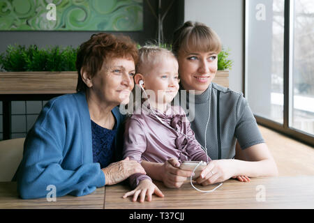 Les femmes d'âges différents à la fenêtre. Grand-mère, fille et sa petite-fille sont assis à proximité. Banque D'Images