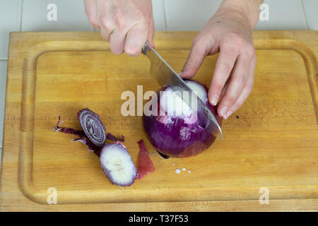 Close up de l'oignon rouge coupé en deux extrémités après ont été coupées par des femmes. Banque D'Images