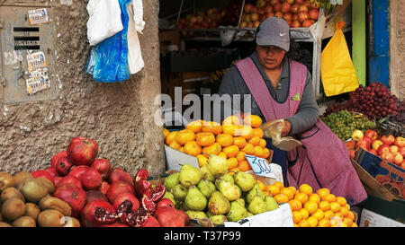 CUSCO, PÉROU- le 20 juin 2016 : une femme sacs, les mandarines dans un marché à Cuzco Banque D'Images