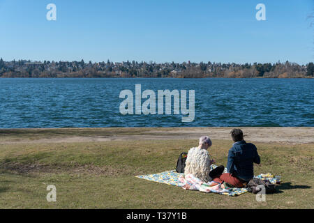 Seattle, Washington - 2019-03-17 - Couple having a picnic in Greenlake le printemps commence à Seattle Banque D'Images