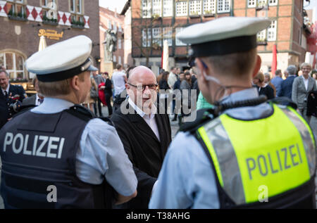 07 avril 2019, en Rhénanie du Nord-Westphalie, Münster : Markus Lewe (CDU), Maire de Münster, se félicite de policiers debout devant le restaurant 'Kiepenkerl'. En souvenir des victimes de l'amok Münster dur il y a un an, en deuil avait jeté des fleurs sur les lieux du crime en face du restaurant 'Kiepenkerl'. Photo : Friso Gentsch/dpa Banque D'Images