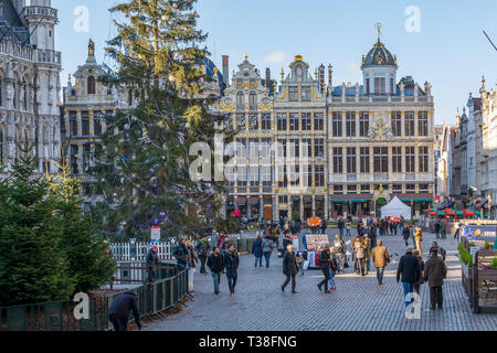 Les touristes sur la célèbre Grand Place de Bruxelles, avec de riches maisons de guilde décoré de sculptures des façades et les arbres de Noël. Banque D'Images