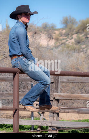 American girl sitting on fence en Arizona Banque D'Images