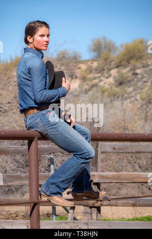 American girl sitting on fence en Arizona Banque D'Images