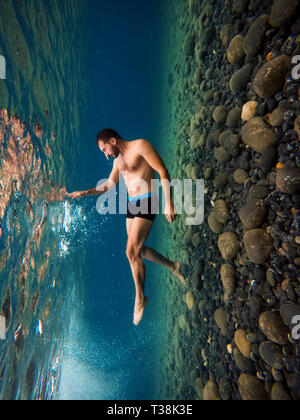 Portrait d'un homme sous l'eau à Mavra Volia plage volcanique. Les pierres sont volcanique. Banque D'Images