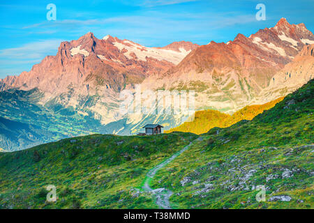 Belle randonnée et voyage destination, lieu touristique des Alpes Suisses avec cabane en bois et de hautes montagnes en arrière-plan au coucher du soleil, Grindelwald, Oberland Banque D'Images