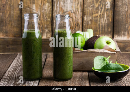 Fruits et légumes vert sain en bouteilles de smoothie sur table en bois rustique, les épinards, l'avocat, la pomme, le céleri et le jus de lime verre avec des ingrédients, Banque D'Images