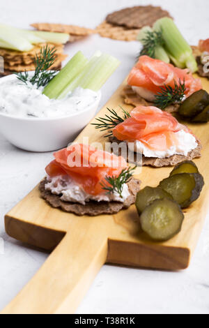 Cuisine de fête, apéritif au saumon pate et saumon fumé, yaourt à l'aneth, du céleri et des cornichons sur planche de bois, snack-platter close-up, se Banque D'Images