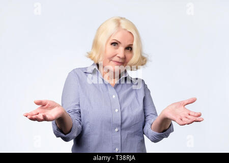 Portrait of a senior woman having nice un doute de geste. Qui sait ou je ne sais pas quoi choisir. Banque D'Images