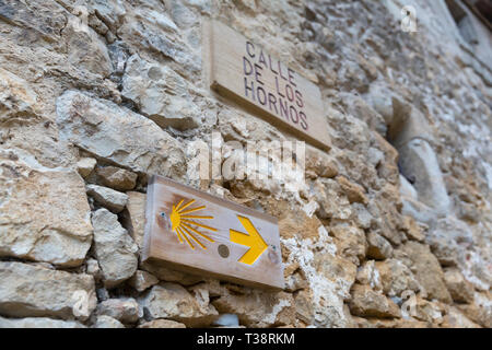 Santillana del Mar, Espagne : marqueur typique le long du Camino del Norte sur la Calle de Los Hornos, près de la Plaza Mayor. La coquille Saint-Jacques et une flèche jaune Banque D'Images