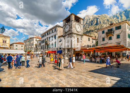 Les touristes visiter, dîner dans des cafés et boutique sous la tour de l'horloge à la place des bras, dans la ville médiévale fortifiée de Kotor, Monténégro Banque D'Images