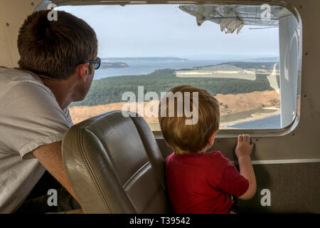 Un père & fils en regardant par la fenêtre d'un petit vol d'hydravion entre Seattle et les îles San Juan. Banque D'Images