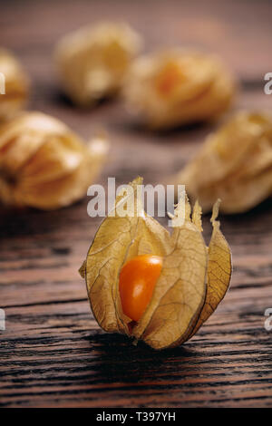 Physalis Peruviana Physalis (fruits) avec enveloppe sur fond de bois Banque D'Images