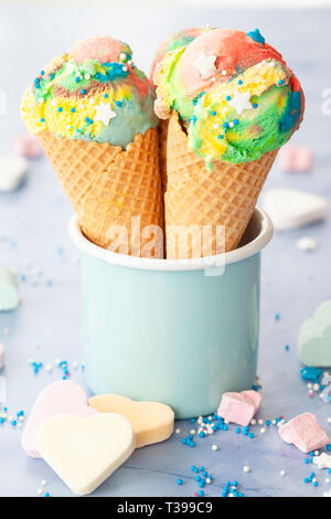 Ice cream cones dans couleurs arc-en-ciel avec des bonbons colorés Banque D'Images